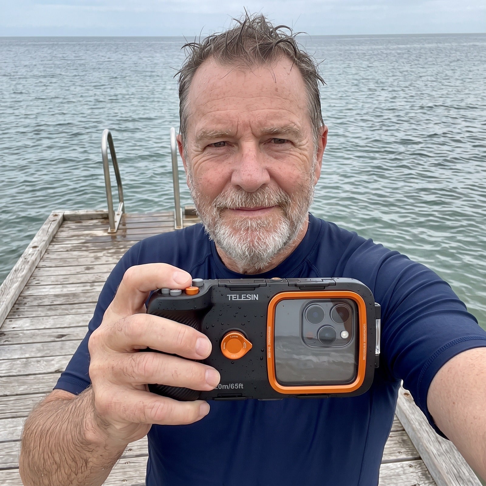 Older man taking a jetty selfie with the Tideglass phone housing