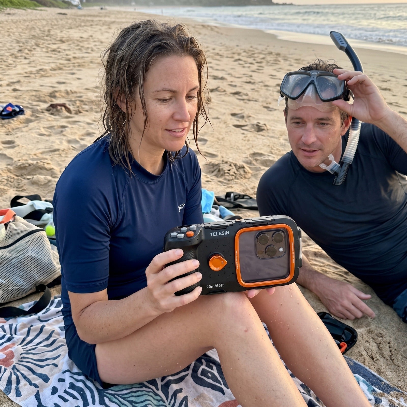 Couple returning from a beach swim with the Tideglass housing